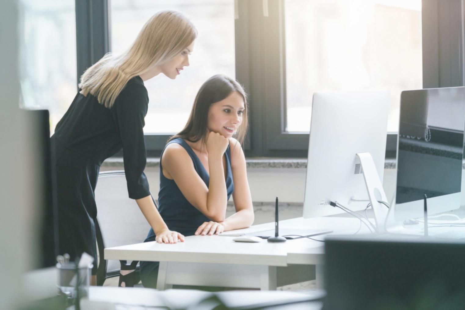 Business team reviewing financial reports and compliance metrics on multiple screens in modern office environment